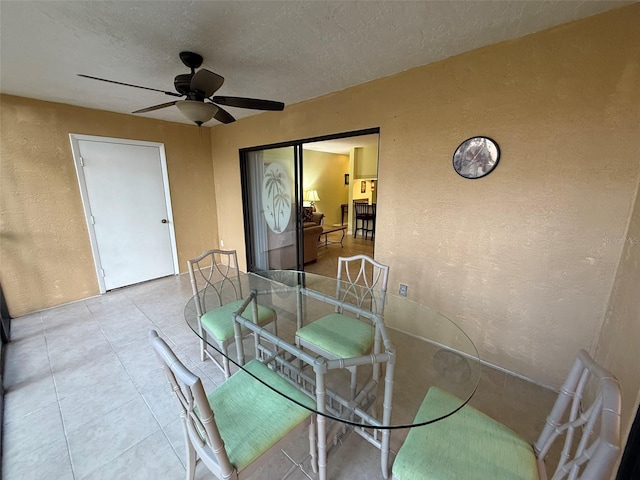 dining space featuring ceiling fan and a textured ceiling