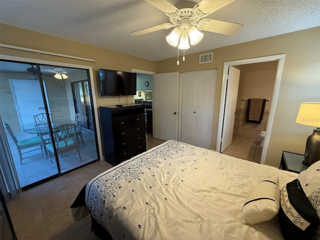 bedroom with ceiling fan, access to exterior, dark tile patterned floors, and a textured ceiling