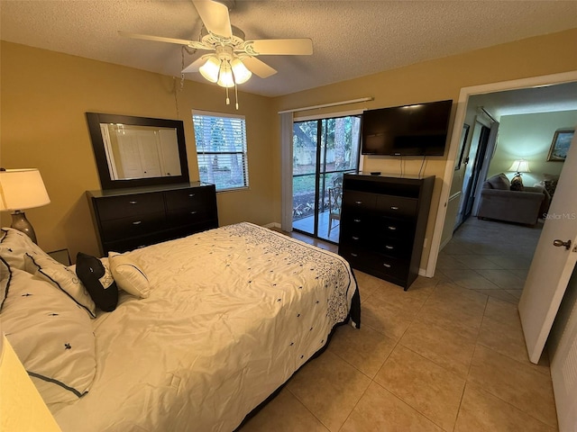 tiled bedroom featuring ceiling fan, access to exterior, and a textured ceiling