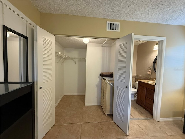 walk in closet with light tile patterned floors