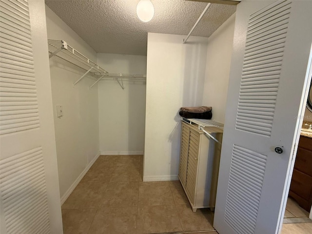 walk in closet featuring light tile patterned flooring