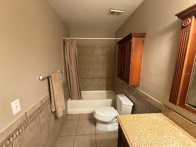 full bathroom with tile patterned floors, vanity, tile walls, toilet, and shower / bath combo