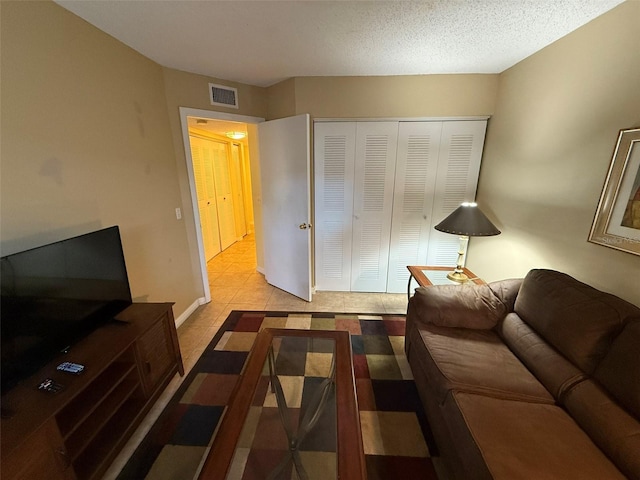 living room with light tile patterned flooring and a textured ceiling