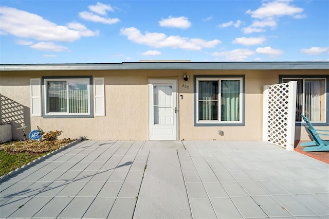 view of exterior entry with a patio