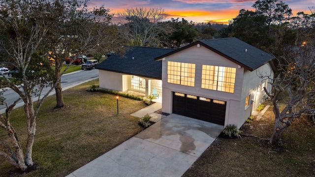 view of front of house with a garage and a yard