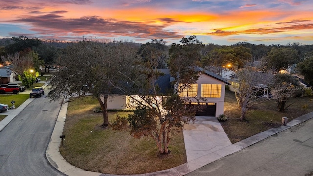 view of front of home with a garage and a yard