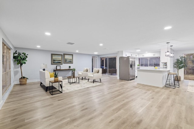 living room featuring light wood-type flooring and a chandelier