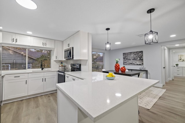 kitchen with appliances with stainless steel finishes, white cabinetry, and sink