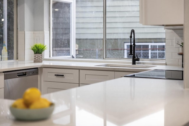 kitchen with white cabinetry, dishwasher, and sink