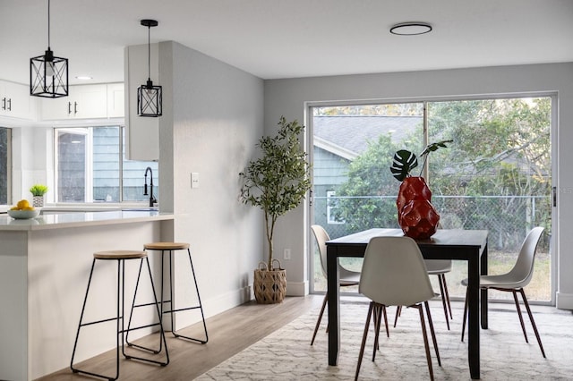 dining space featuring plenty of natural light, light hardwood / wood-style flooring, and sink