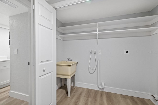 laundry room featuring light wood-type flooring, washer hookup, and electric dryer hookup