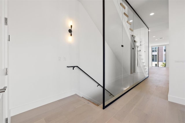 stairs featuring floor to ceiling windows and hardwood / wood-style floors