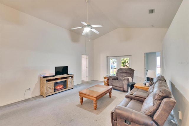 living room featuring ceiling fan, light carpet, french doors, and vaulted ceiling