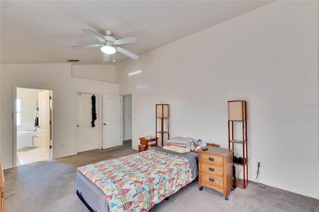 carpeted bedroom featuring ceiling fan, connected bathroom, and lofted ceiling