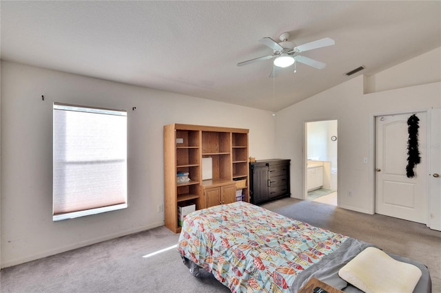 bedroom featuring ceiling fan, light colored carpet, connected bathroom, and lofted ceiling