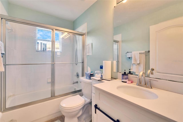 full bathroom with toilet, bath / shower combo with glass door, and vanity