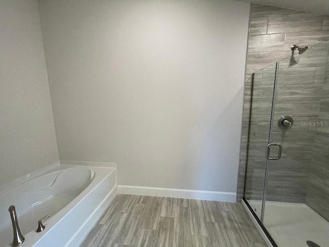 bathroom with hardwood / wood-style floors and separate shower and tub