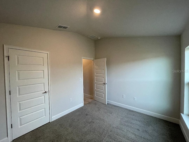 unfurnished bedroom featuring dark carpet