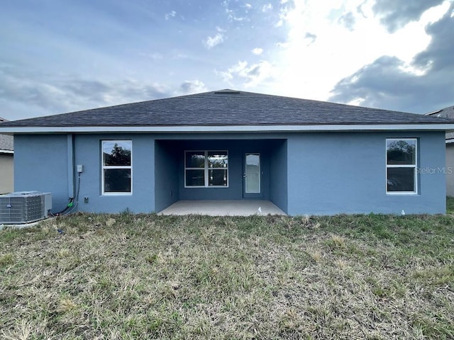 back of property featuring a patio area, a lawn, and central AC