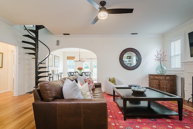 living room featuring hardwood / wood-style floors, crown molding, and ceiling fan with notable chandelier