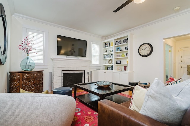 living room with a brick fireplace, ornamental molding, and ceiling fan