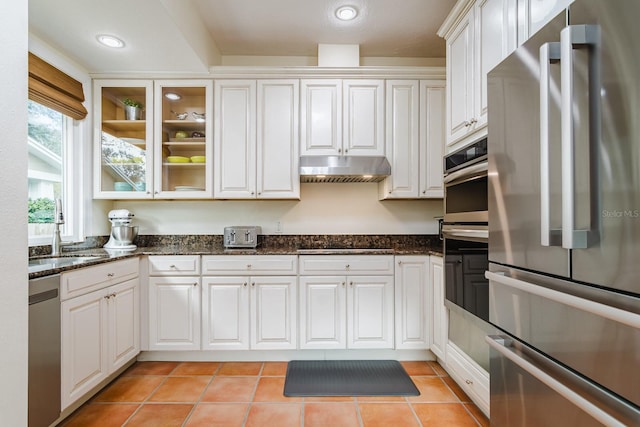 kitchen featuring white cabinetry, sink, dark stone countertops, and appliances with stainless steel finishes