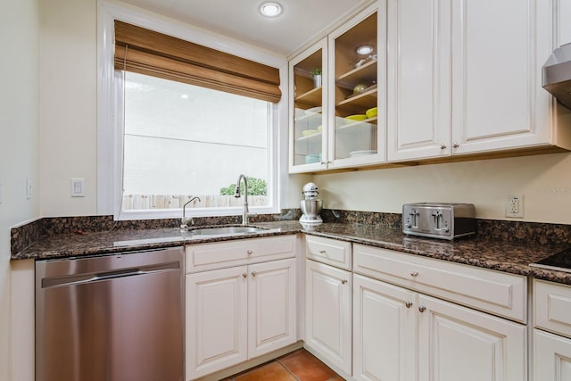 kitchen with dishwasher, sink, dark stone countertops, and white cabinets