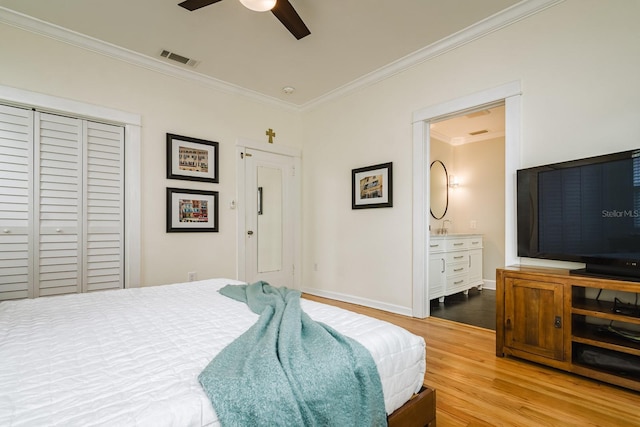 bedroom with connected bathroom, hardwood / wood-style flooring, ceiling fan, crown molding, and a closet