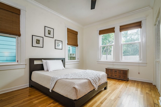 bedroom featuring crown molding, light hardwood / wood-style flooring, and ceiling fan