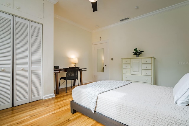 bedroom featuring hardwood / wood-style flooring, ornamental molding, ceiling fan, and a closet