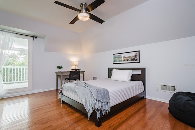 bedroom featuring multiple windows, hardwood / wood-style flooring, access to outside, and ceiling fan