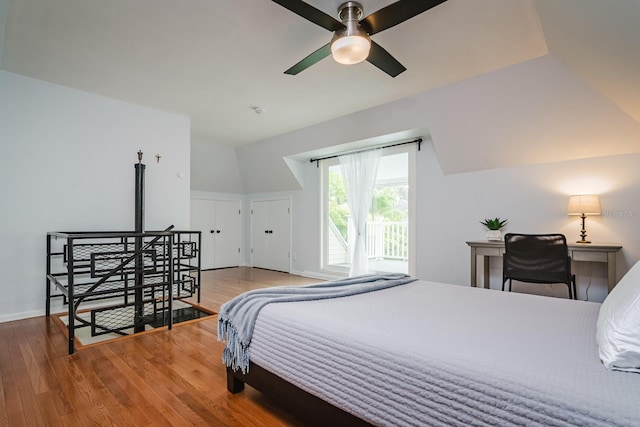 bedroom with hardwood / wood-style flooring, vaulted ceiling, and ceiling fan