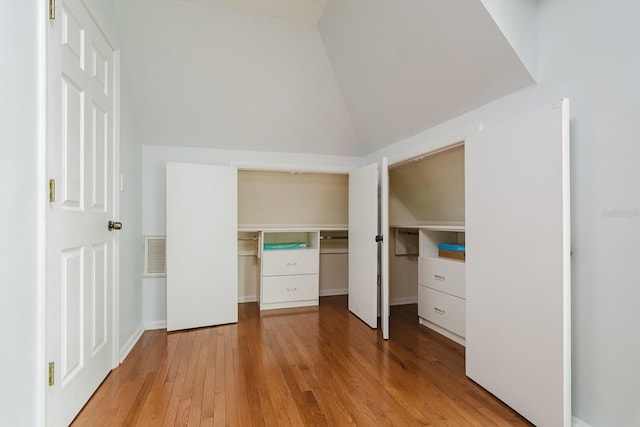 unfurnished bedroom with lofted ceiling and light hardwood / wood-style flooring