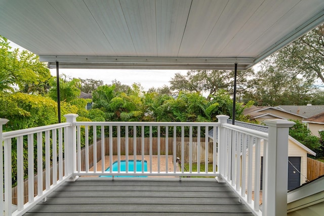 wooden deck with a fenced in pool