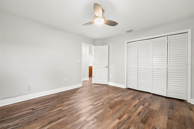 unfurnished bedroom featuring ceiling fan, dark hardwood / wood-style floors, and a closet