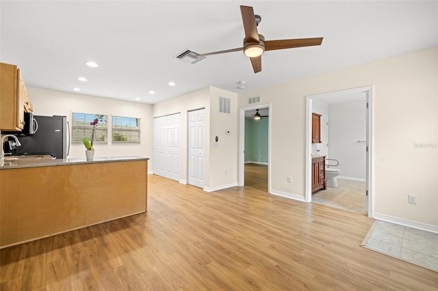 kitchen featuring sink, range, light wood-type flooring, stainless steel fridge, and ceiling fan