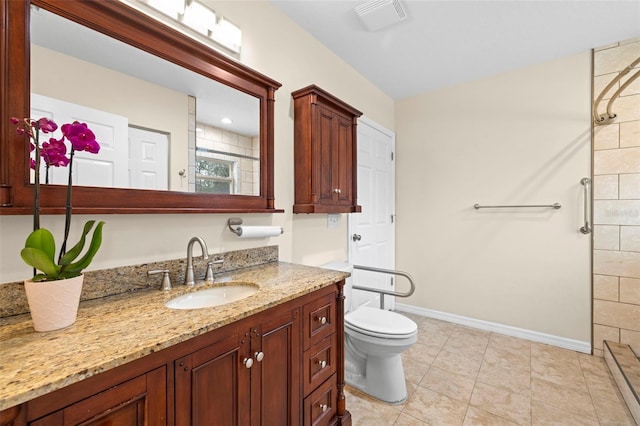 bathroom featuring tile patterned floors, vanity, toilet, and a shower