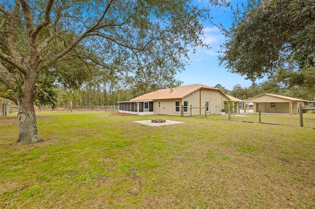 view of yard with a sunroom and a fire pit