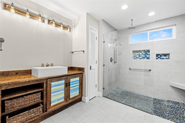 bathroom with tiled shower and sink