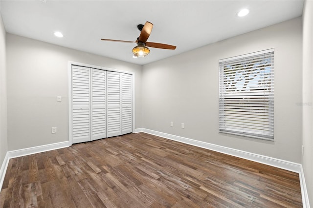 unfurnished bedroom with a closet, dark hardwood / wood-style floors, and ceiling fan