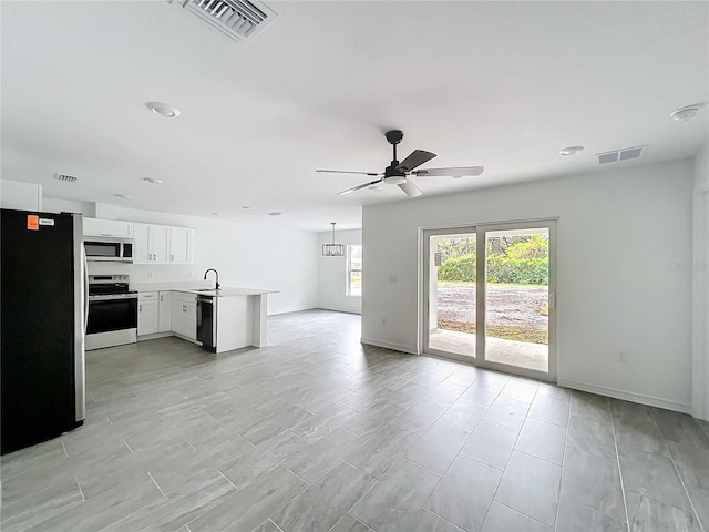 kitchen featuring open floor plan, stainless steel appliances, light countertops, and visible vents