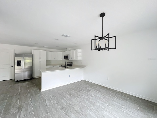 kitchen with visible vents, light countertops, appliances with stainless steel finishes, a sink, and a peninsula