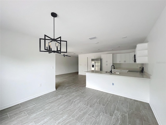 kitchen featuring visible vents, white cabinets, a peninsula, stainless steel appliances, and light countertops