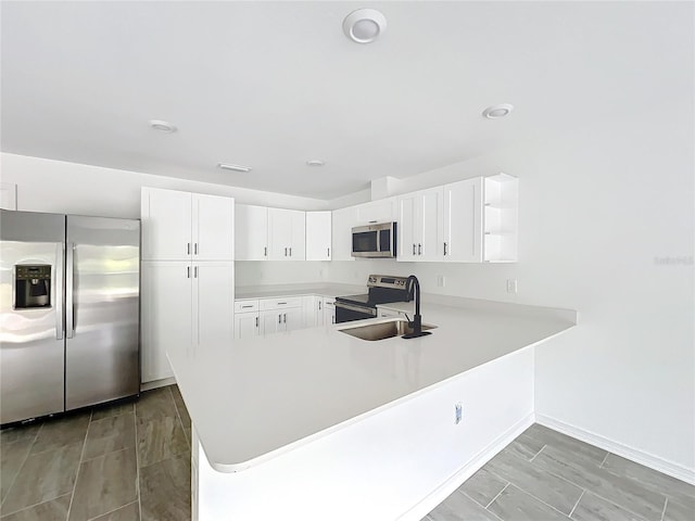 kitchen featuring open shelves, stainless steel appliances, a sink, and light countertops