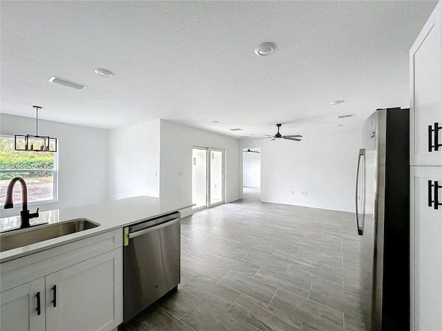 kitchen featuring decorative light fixtures, visible vents, appliances with stainless steel finishes, a sink, and ceiling fan