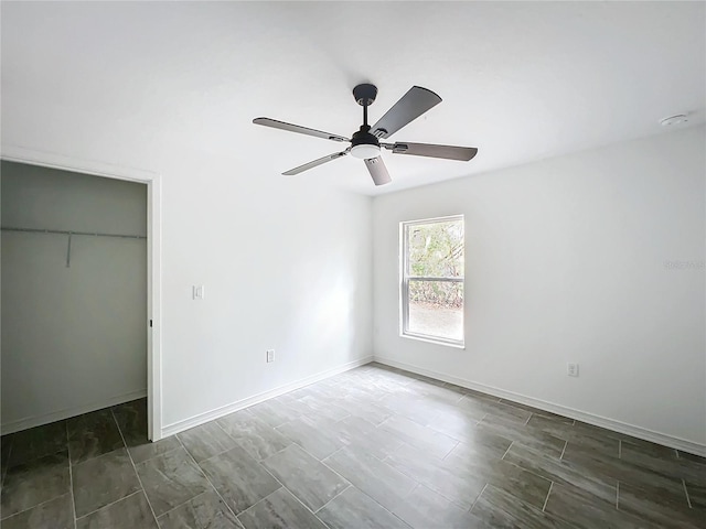 unfurnished bedroom featuring ceiling fan, baseboards, and a closet