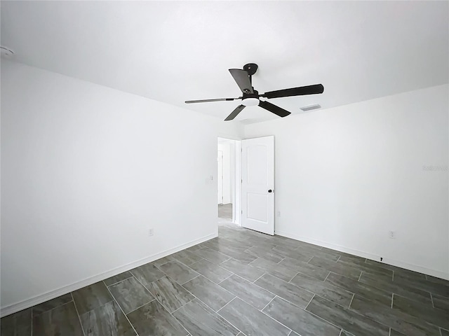 empty room featuring a ceiling fan, visible vents, and baseboards