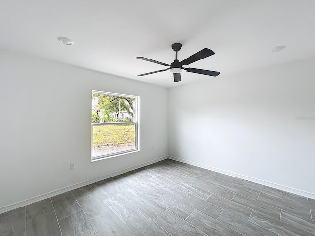 spare room featuring ceiling fan and baseboards