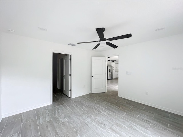 spare room featuring visible vents, baseboards, and ceiling fan