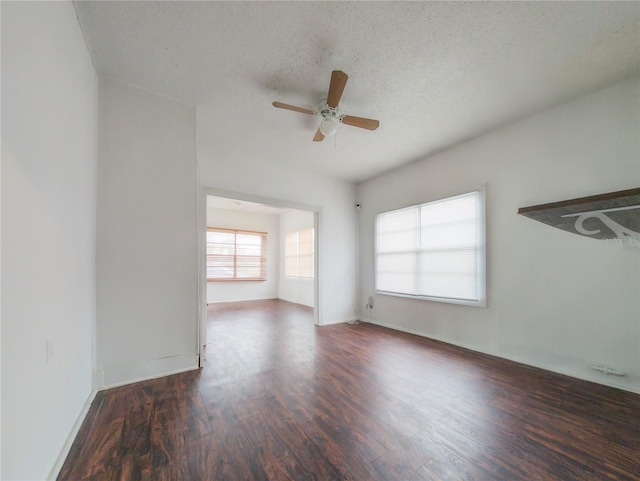 unfurnished room with a textured ceiling, ceiling fan, and dark wood-type flooring